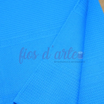 Toalha azul texturizada dobrada sobre superfície de madeira clara