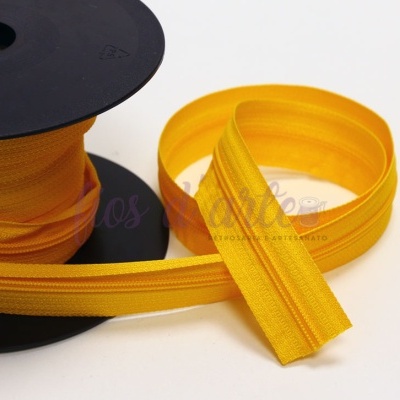 Rolo de fecho éclair amarelo em tecido com dentes amarelos