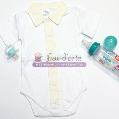 Body branco de bebé com gola creme, chupeta azul e mamadeira transparente com tampa verde