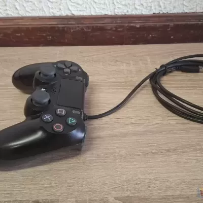 Comando de jogo preto com fio sobre superfície de madeira