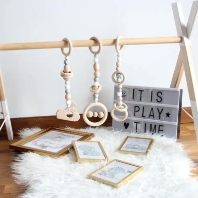 Brinquedo de berço de madeira com argolas e caixa luminosa com texto em branco