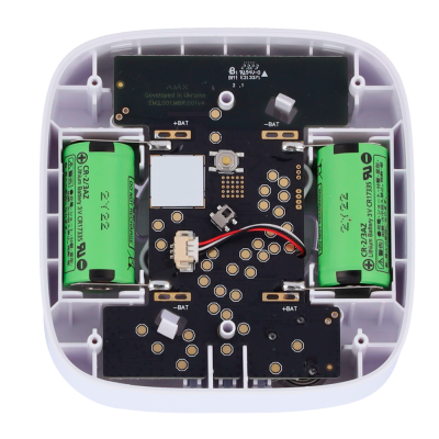 Interior de dispositivo eletrónico com baterias verdes e placa de circuito preto