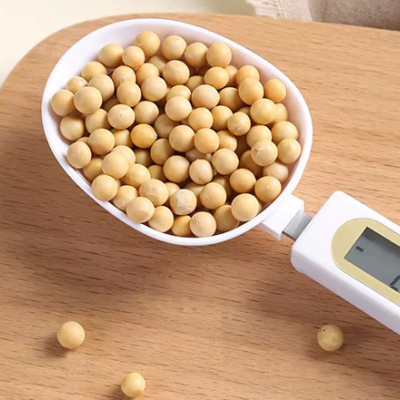 Colher medidora digital branca com visor LCD a pesar grãos amarelos redondos