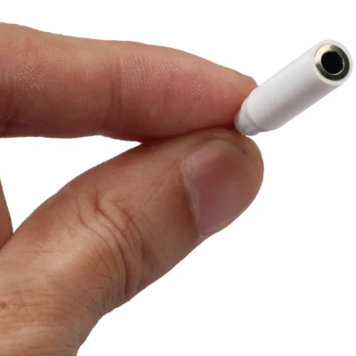 Mão segurando adaptador de áudio branco com jack de 3,5 mm.