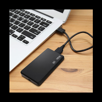 Disco rígido externo preto ligado a portátil sobre mesa de madeira