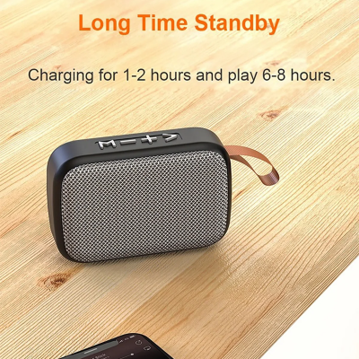 Coluna de som portátil preta com grelha cinza e texto explicativo em fundo de madeira