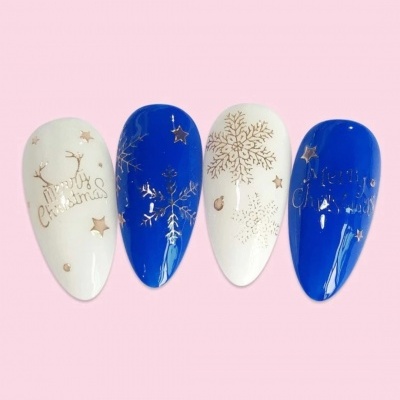 Unhas postiças azul e branco com desenhos natalícios em fundo rosa