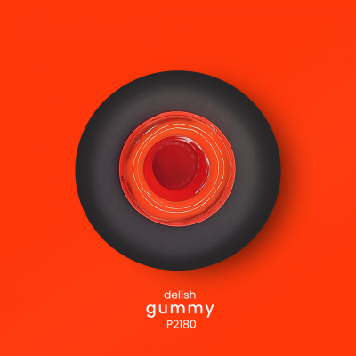 Objeto redondo preto e vermelho com texto 'delish gummy P2180' num fundo vermelho