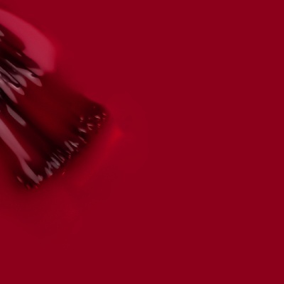 Pincel aplicando esmalte vermelho brilhante sobre superfície similar