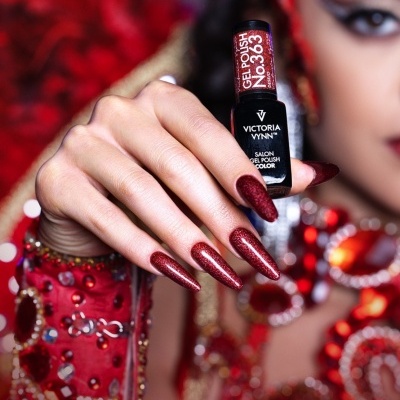 Esmalte em gel Victoria Vynn cor 363 Desejo com unhas vermelhas holográficas e decoração vermelha ao fundo