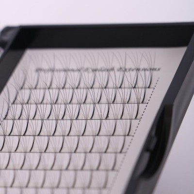 Caixa com extensões de pestanas sintéticas pretas organizadas em fileiras