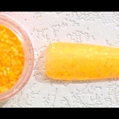 Recipiente transparente com grânulos amarelos e objecto amarelo alongado sobre superfície branca.