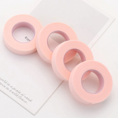 Quatro rolos de fita adesiva rosa sobre papel branco com texto parcial