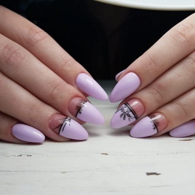 Unhas artificiais em gel lilás com decoração preta floral e riscas pretas sobre mesa branca