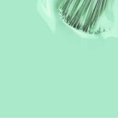 Pincel com tinta verde claro sobre superfície pintada