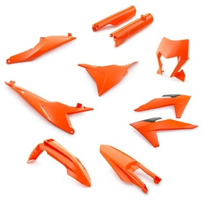 Peças plásticas laranja para motocicleta dispostas em fundo branco