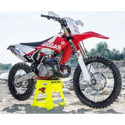 Motocross GASGAS vermelha e branca em suporte amarelo ao ar livre