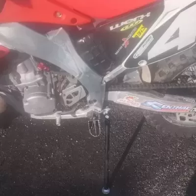 Motocross vermelha com número 42 e adesivos visíveis