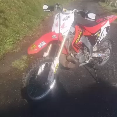 Motocross Honda vermelha e branca com autocolantes