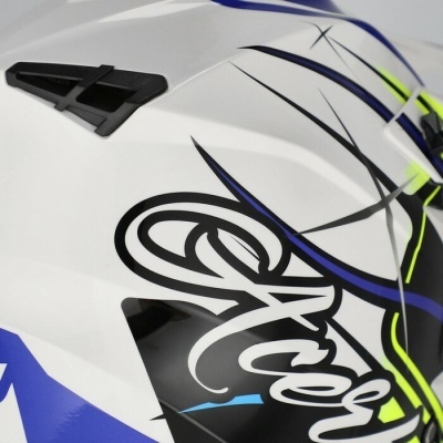 Capacete motocross branco com detalhes gráficos coloridos e ventilação.