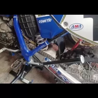 Motocross azul com adesivos AMa Pro Racing e Cometic, roda traseira com pneu cravado e número 1.