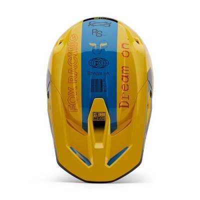 Capacete amarelo com faixas azuis e texto 'FOX RACING' e 'Dream on'