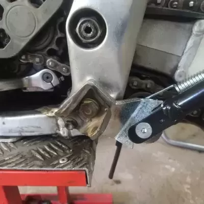 Peças metálicas de motocicleta com corrente e plataforma antiderrapante vermelha