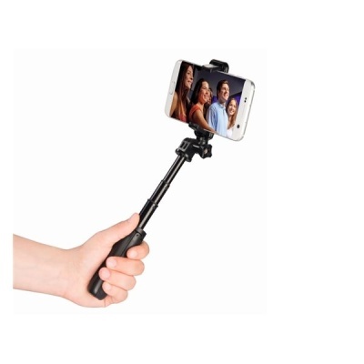 Selfie stick preto com telemóvel segurando uma foto de quatro pessoas