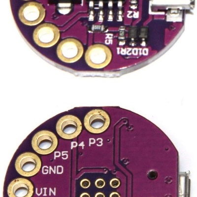 Placa eletrónica redonda roxa com microchip, contatos dourados e conector USB micro