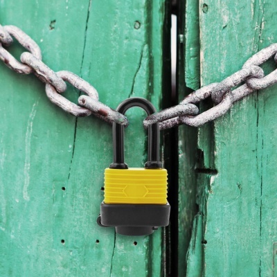 Cadeado amarelo com corrente metálica em portas verdes desgastadas