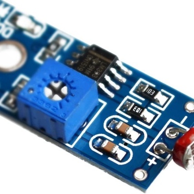 Placa eletrónica azul com potenciômetro azul e sensor fotoeléctrico