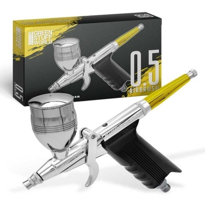 Aerógrafo metálico prateado e caixa preta e amarela com texto.