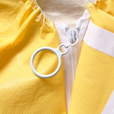 Fecho éclair branco com puxador circular numa peça de roupa amarela