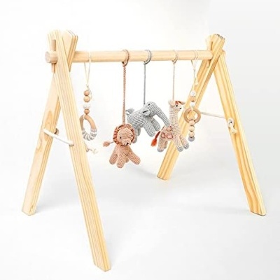 Estrutura de madeira clara com brinquedos de croché pendurados para bebés