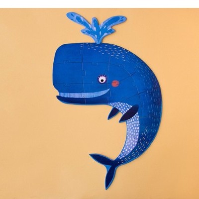 Boneco de baleia azul pendurado numa parede castanha clara