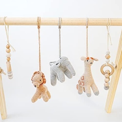 Brinquedos pendurados em croché e madeira em estrutura de madeira clara