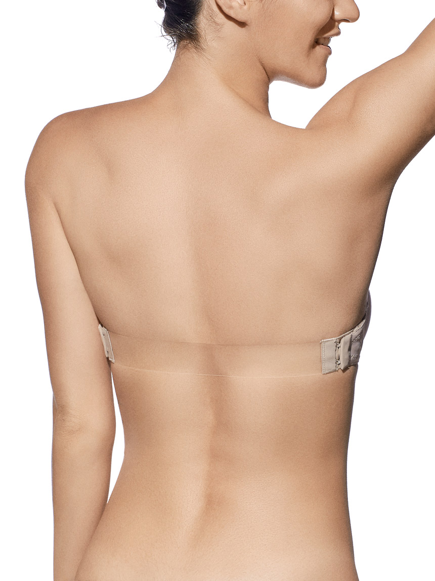 Mulher de costas usando sutiã sem alças bege com fecho e faixa transparente.