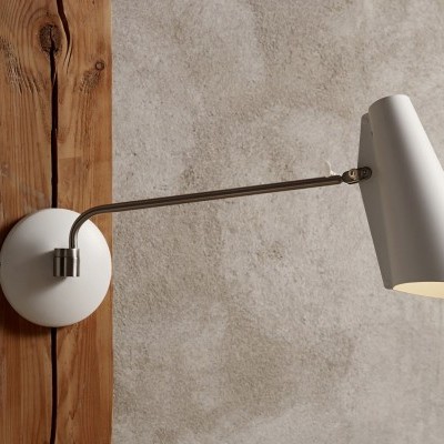 Candeeiro de parede branco com braço metálico e parede cinzenta com madeira