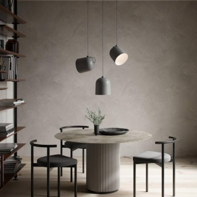 Mesa de jantar redonda com cadeiras pretas e candeeiros pendentes cinzentos em ambiente minimalista