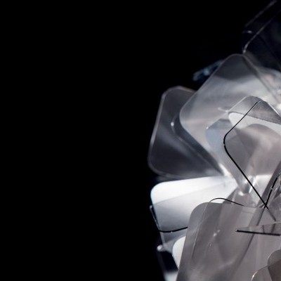 Escultura abstrata feita de placas transparentes sobre fundo preto