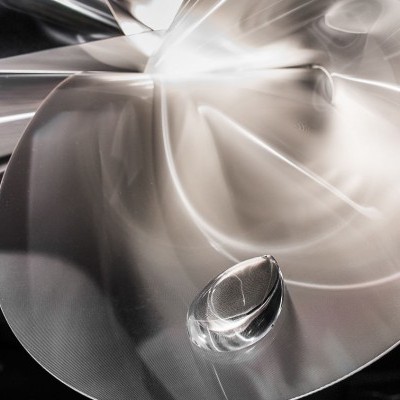 Estrutura metálica curva com reflexos em ambiente interior com quadros