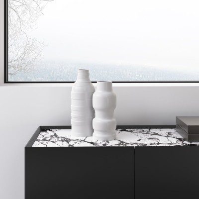 Duas jarras brancas decorativas em cerâmica sobre cómoda preta com tampo de mármore