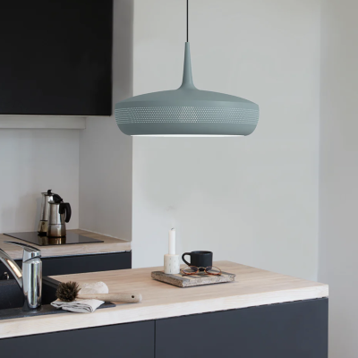 Candeeiro suspenso azul gelo com padrão circular perfurado numa cozinha moderna