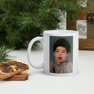 Caneca branca com fotografia de menino e decoração natural em fundo branco