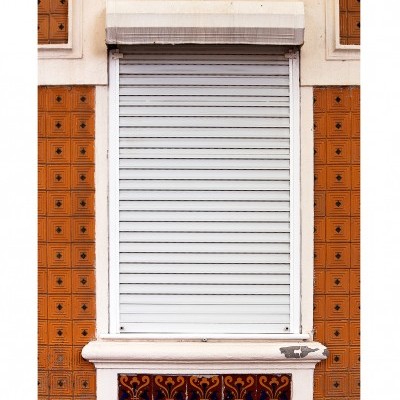 Janela branca com porta de enrolar e azulejos castanhos decorativos