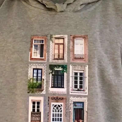 Camisola cinzenta com estampa de nove janelas distintas organizadas em grelha.