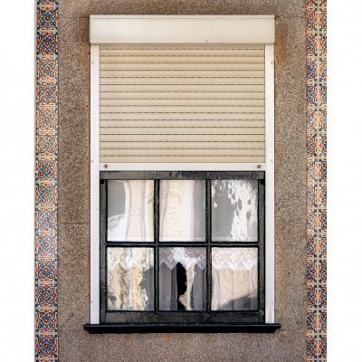 Janela com persiana branca e azulejos coloridos à volta