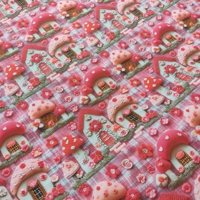 Pano com padrão de casinhas cor-de-rosa e vermelhas com flores em fundo rosa