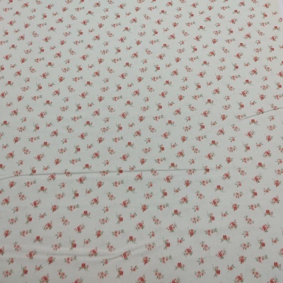 Tecido branco com padrão de pequenas flores rosa e folhas verdes