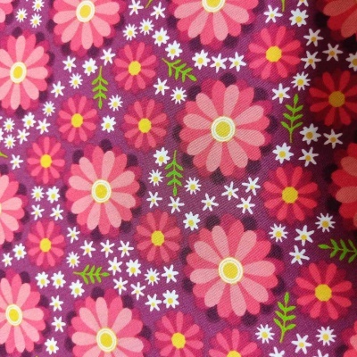 Tecido com padrão floral rosa, vermelho, branco e verde sobre fundo roxo